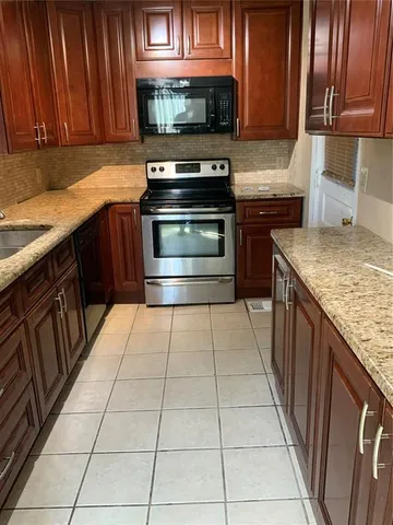 a kitchen with stainless steel appliances granite countertop a stove a sink and a microwave