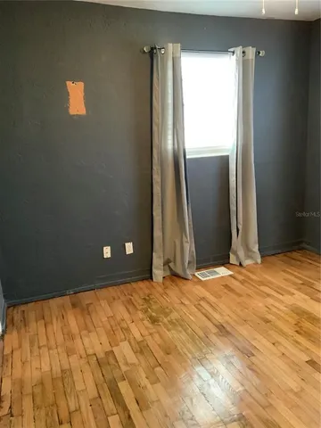 a view of an empty room with wooden floor