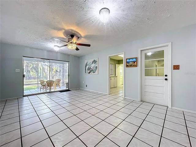 an empty room with a ceiling fan and a window
