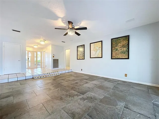 a dining room with furniture a chandelier and glass door