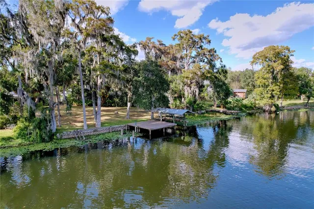 a view of a house with a swimming pool and a yard