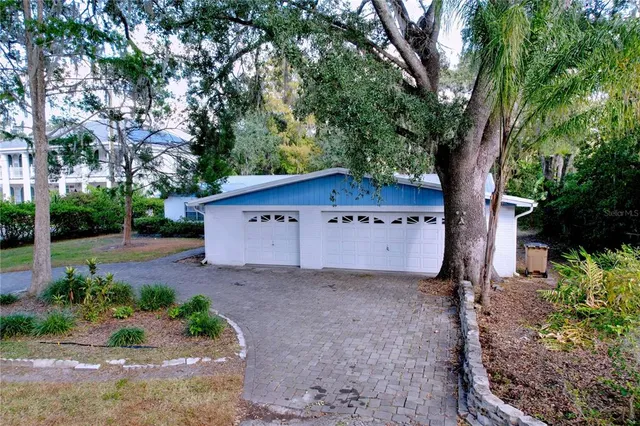 an aerial view of residential house with green space and trees all around