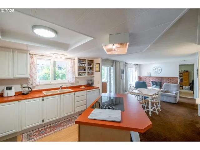 a kitchen with kitchen island a counter top space a sink stainless steel appliances and cabinets