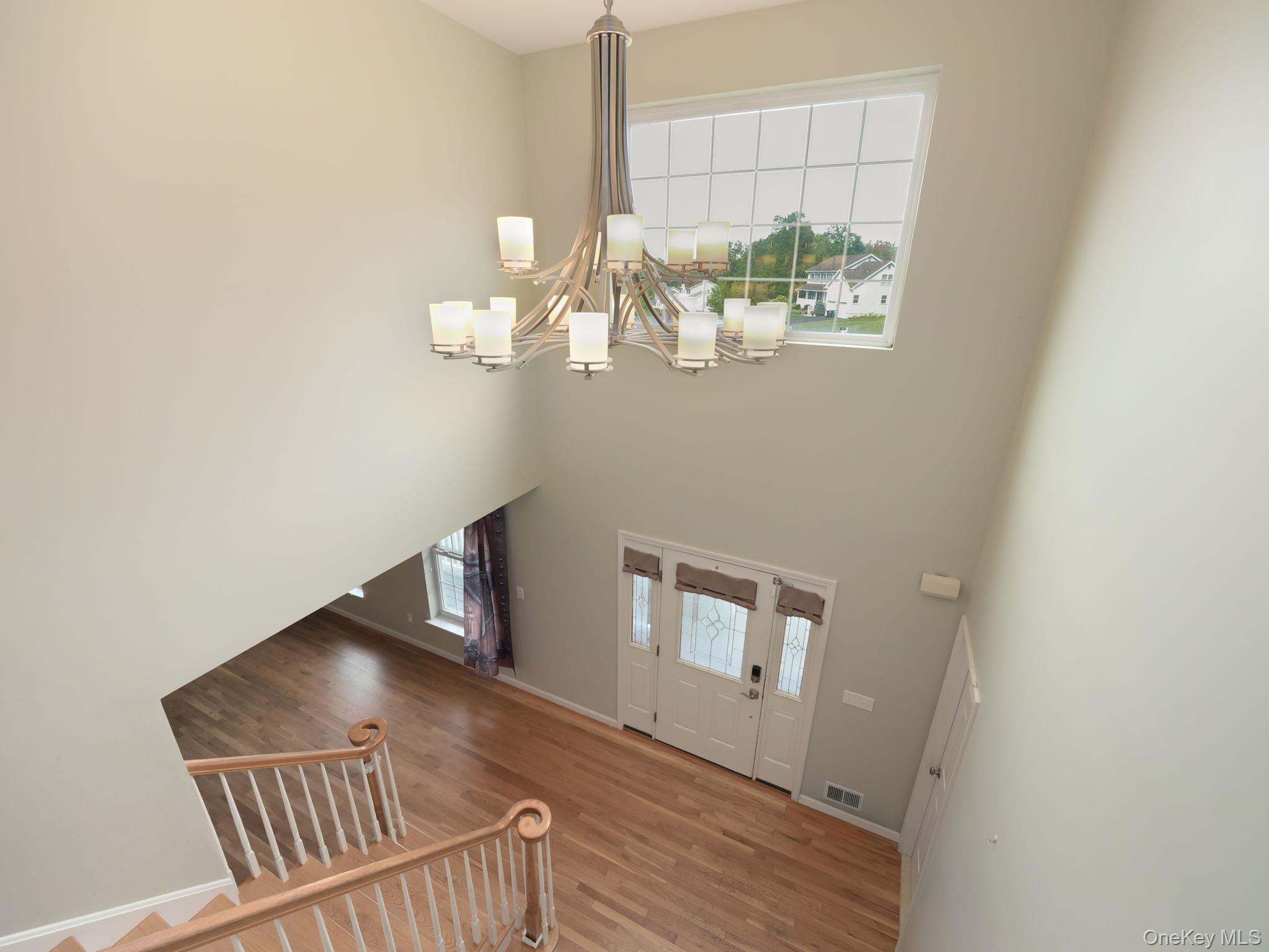 74 Red Maple Way New Windsor, NY 12553 - Photo 20 of 25 Foyer entrance featuring light wood-style flooring, a high ceiling, and a chandelier