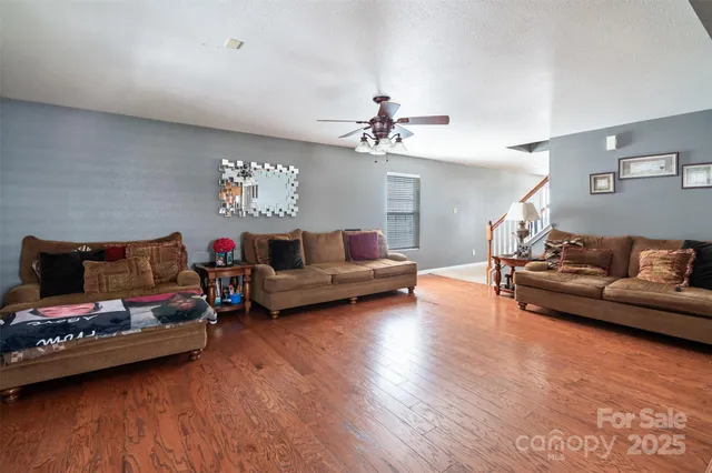 a kitchen with stainless steel appliances granite countertop a sink a stove a kitchen island with chairs and wooden floor