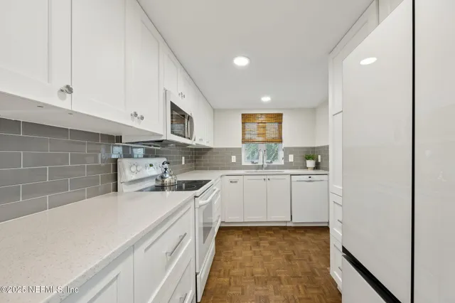 a kitchen with a sink cabinets and wooden floor