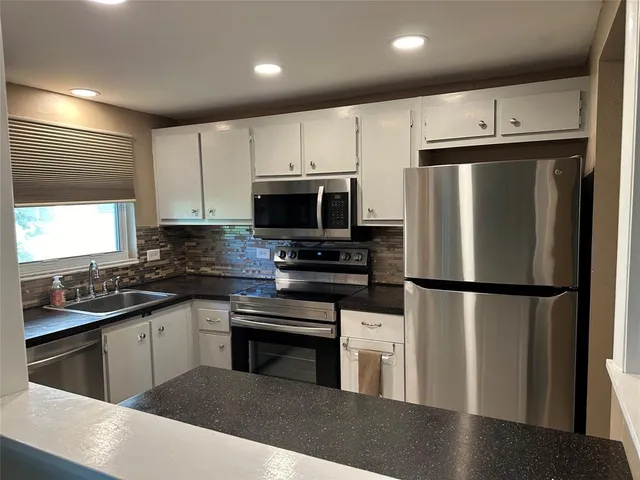 a kitchen with stainless steel appliances a refrigerator sink and microwave