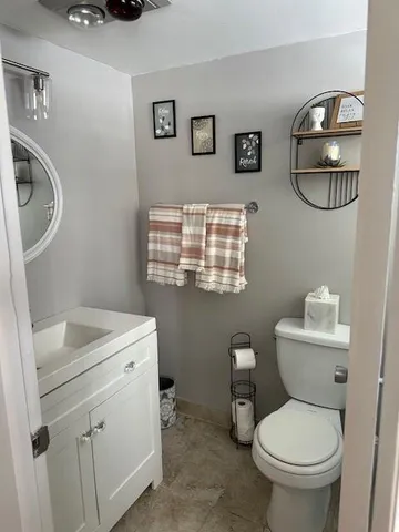 a bathroom with a toilet a sink and a mirror