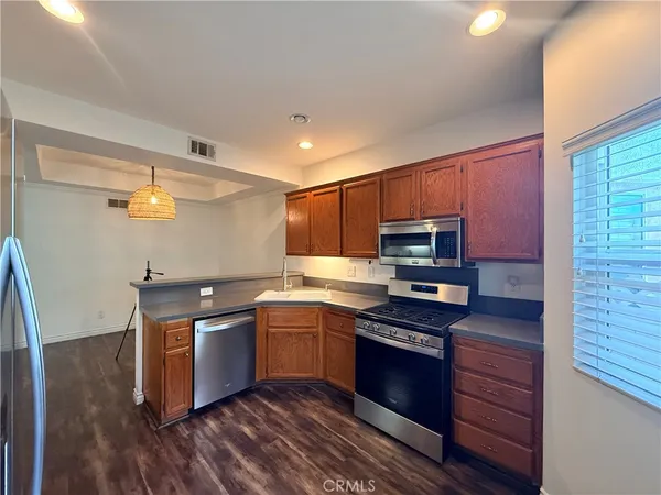 a kitchen with stainless steel appliances granite countertop a stove a sink and a refrigerator