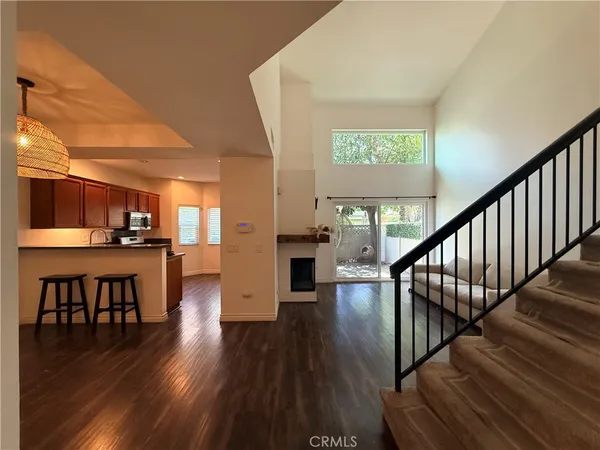 a view of a room with wooden floor windows and kitchen view