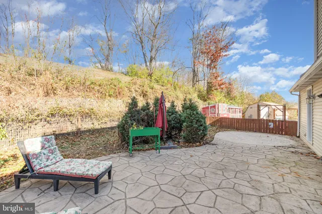 a view of a chair and table in backyard of the house