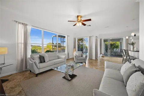 a living room with furniture ceiling fan and a window