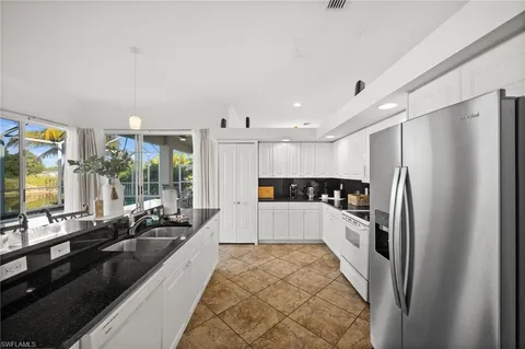 a large white kitchen with a large window