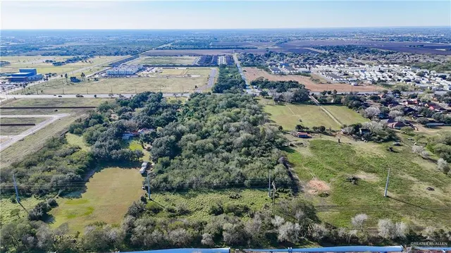 an aerial view of residential houses with outdoor space and trees