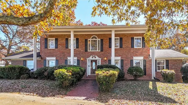a view of a brick house with a yard