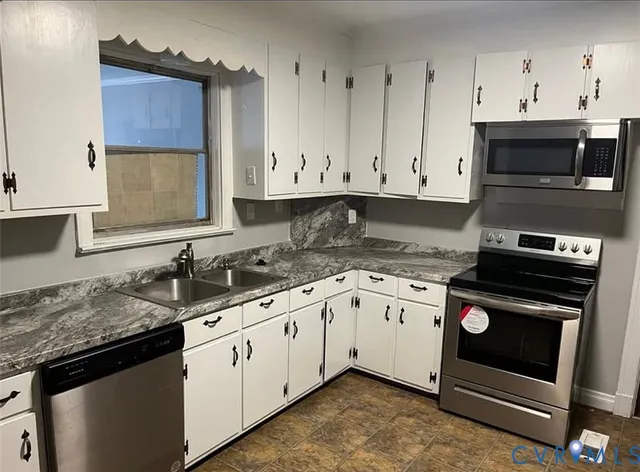 a kitchen with stainless steel appliances a refrigerator a stove and cabinets