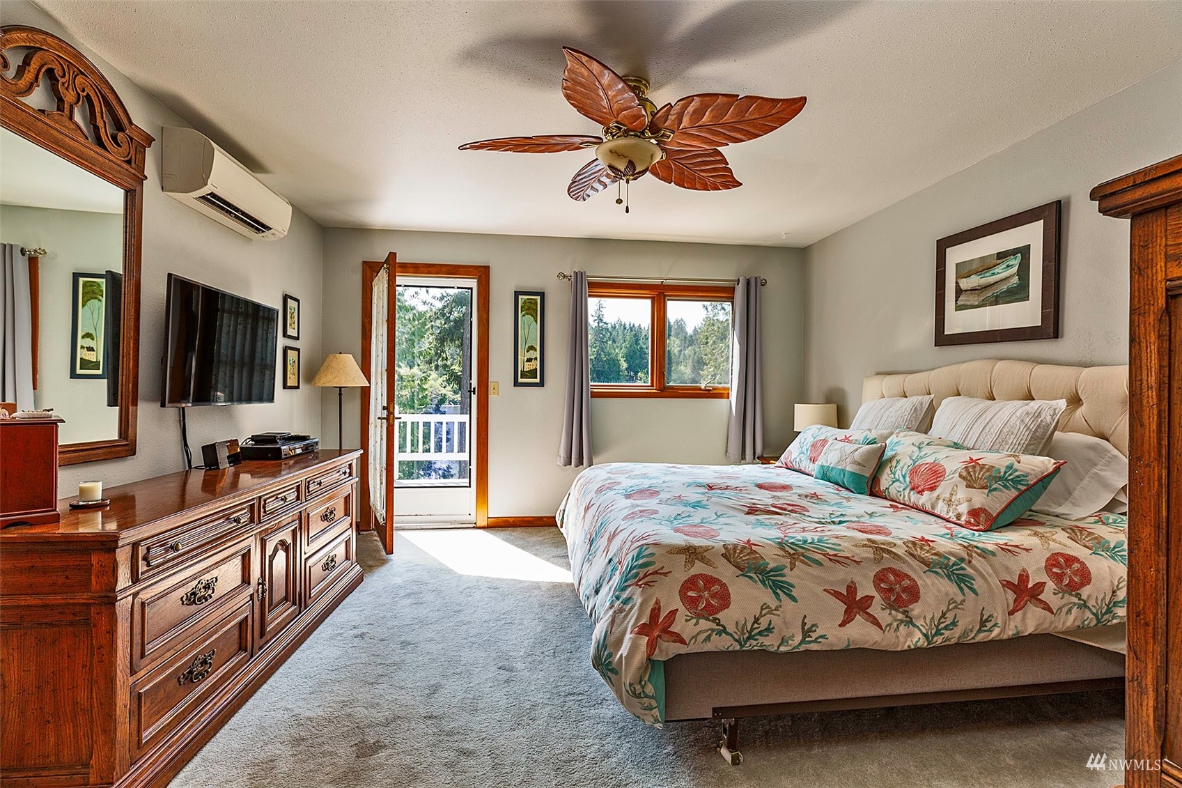 10518 Guthrie Road Anderson Island, WA 98303 - Photo 21 of 40 a bedroom with a large bed a flat tv screen and dresser