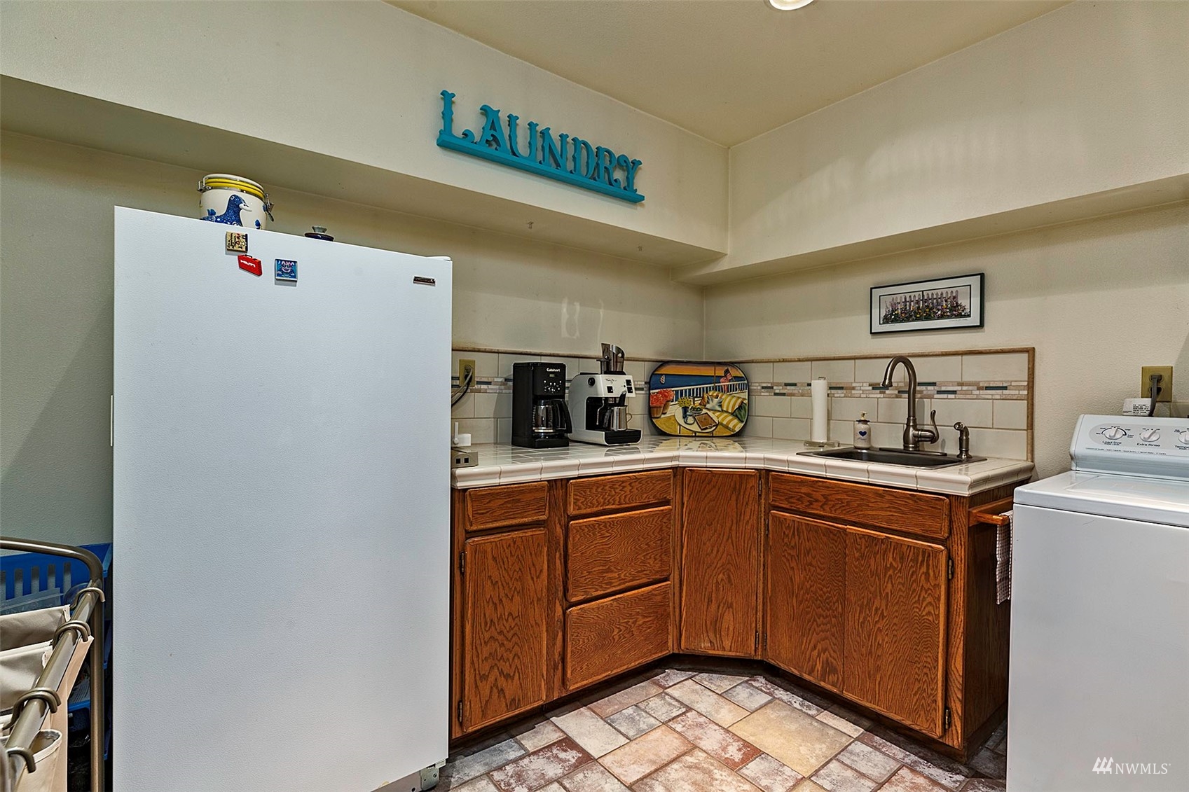 10518 Guthrie Road Anderson Island, WA 98303 - Photo 31 of 40 a kitchen with a sink a refrigerator and cabinets