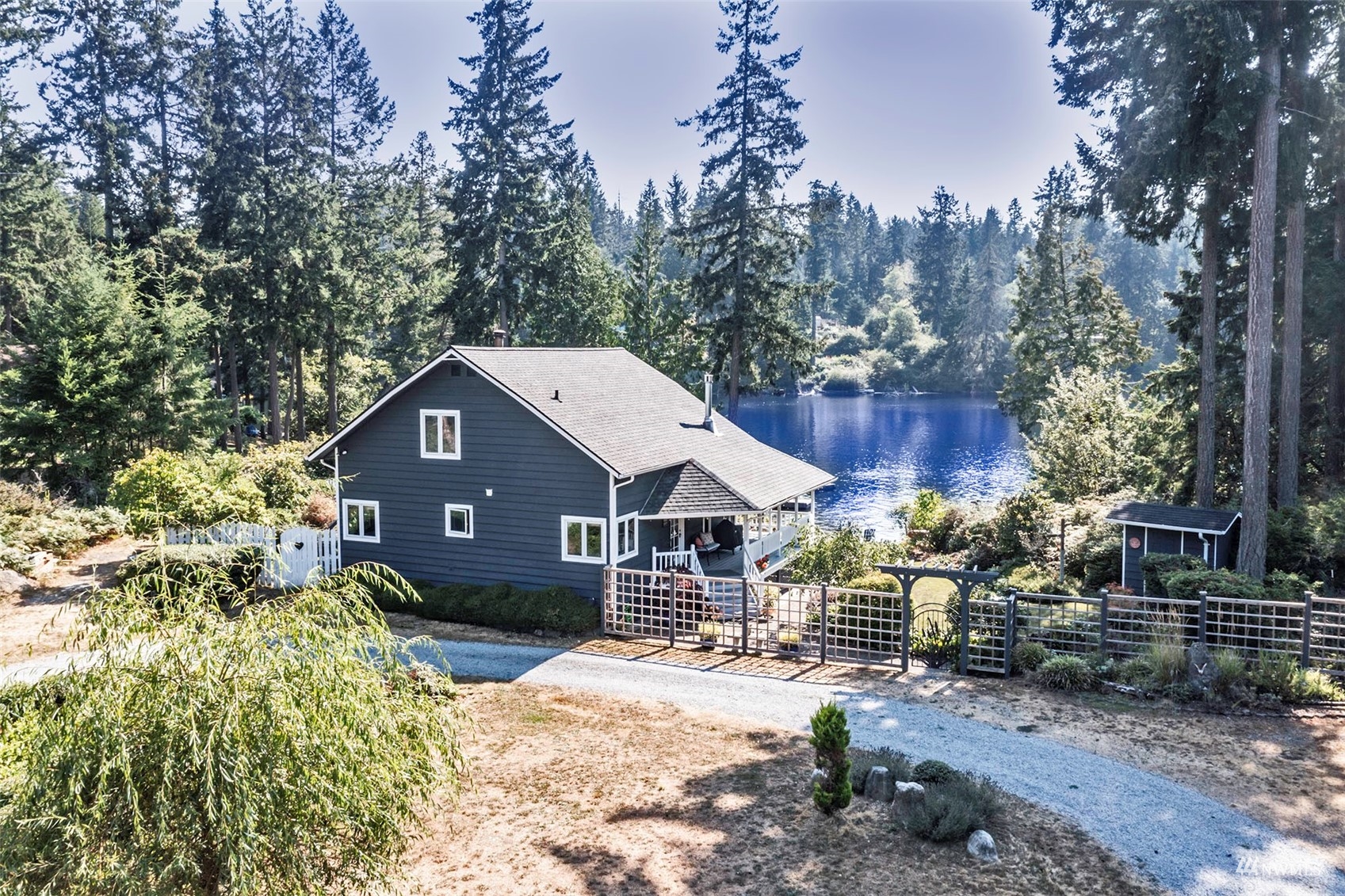10518 Guthrie Road Anderson Island, WA 98303 - Photo 4 of 40 a front view of a house with a yard covered with trees