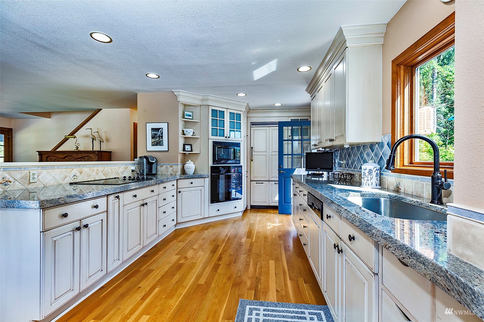 10518 Guthrie Road Anderson Island, WA 98303 - Photo 10 of 40 a large kitchen with granite countertop a large window and stainless steel appliances