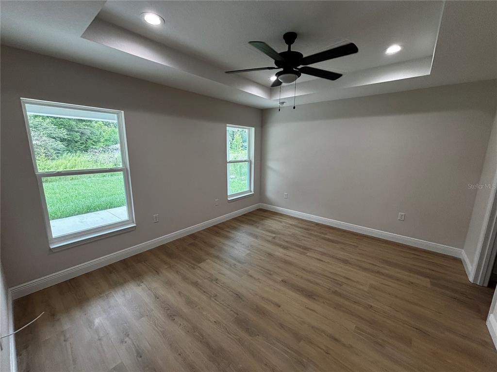 3148 Southwest 145th Court Ocala, FL 34481 - Photo 14 of 17 an empty room with wooden floor fan and windows