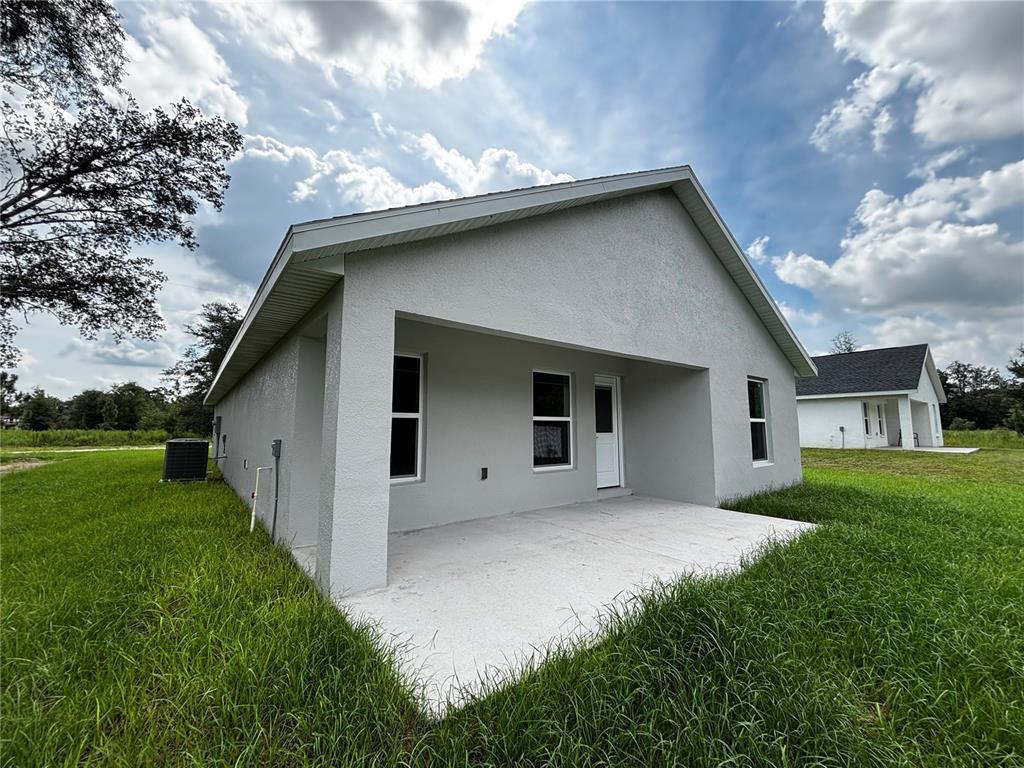 3148 Southwest 145th Court Ocala, FL 34481 - Photo 16 of 17 a house with a big yard potted plants in front of it