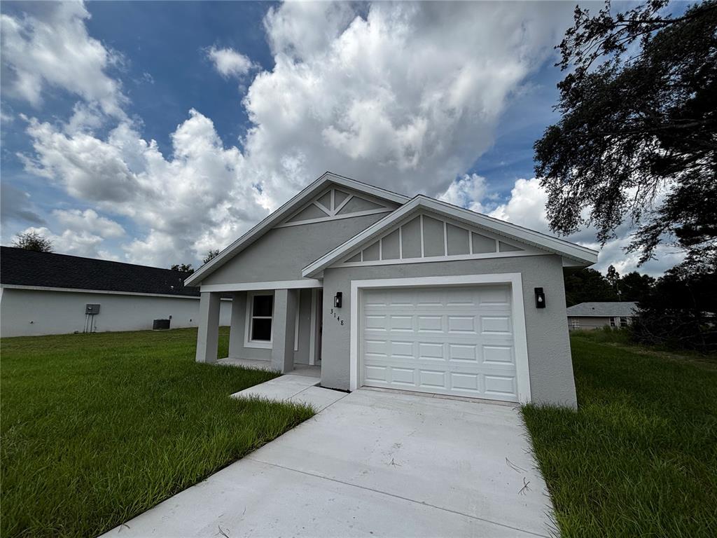 3148 Southwest 145th Court Ocala, FL 34481 - Photo 2 of 17 a front view of house with yard and green space