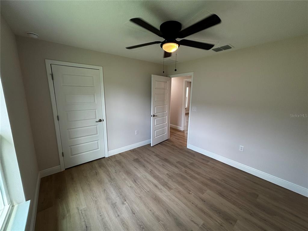 3148 Southwest 145th Court Ocala, FL 34481 - Photo 8 of 17 an empty room with wooden floor and windows