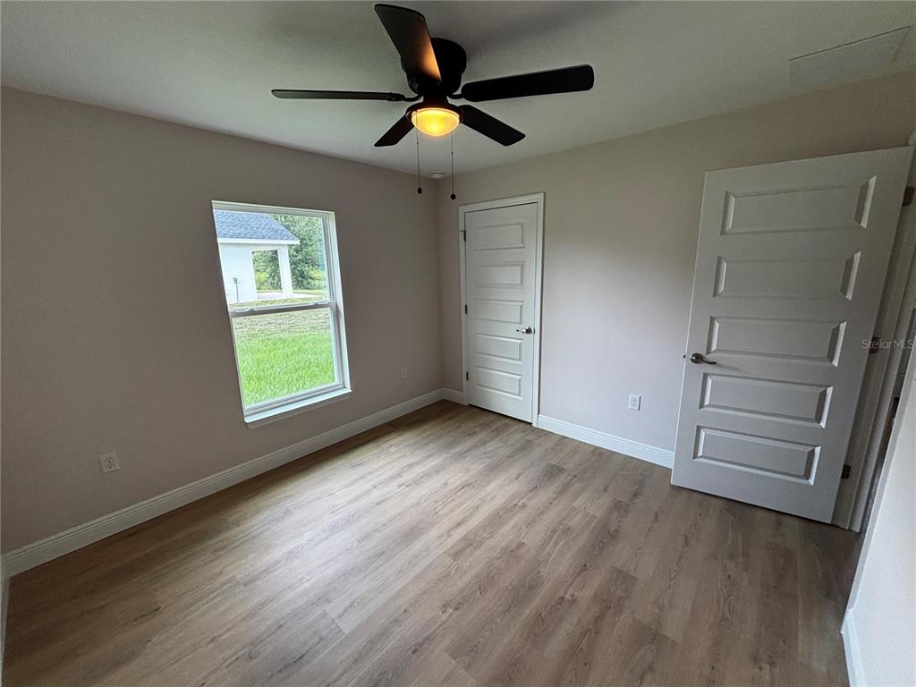 3148 Southwest 145th Court Ocala, FL 34481 - Photo 10 of 17 an empty room with wooden floor fan and windows