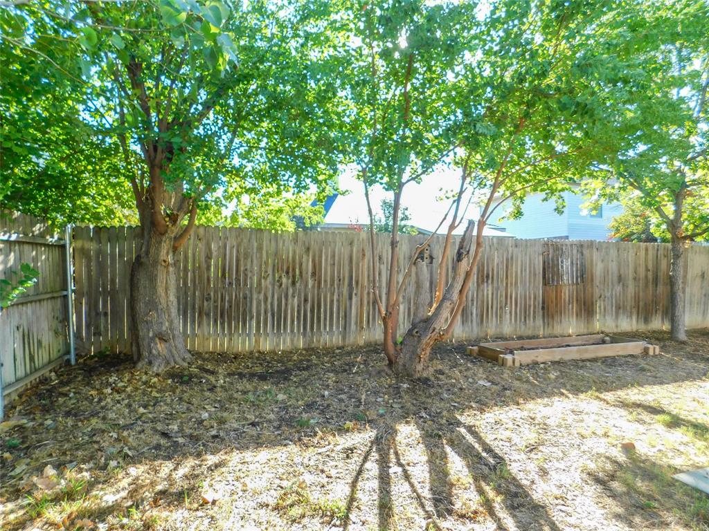 8105 Winding Stream Lane Denton, TX 76210 - Photo 26 of 28 a backyard of a house with large trees and wooden fence