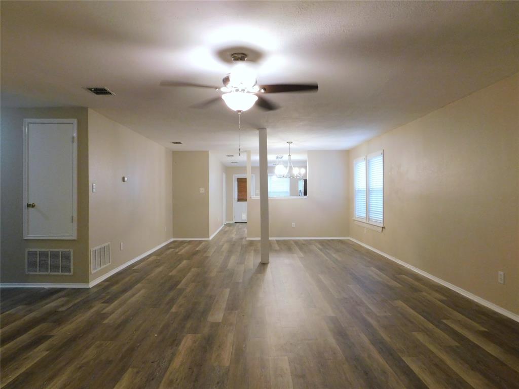 8105 Winding Stream Lane Denton, TX 76210 - Photo 6 of 28 a view of an empty room with wooden floor and a window