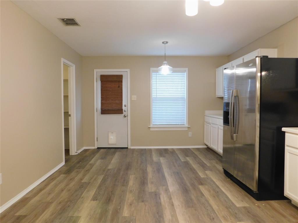 8105 Winding Stream Lane Denton, TX 76210 - Photo 9 of 28 an empty room with wooden floor and a bathroom