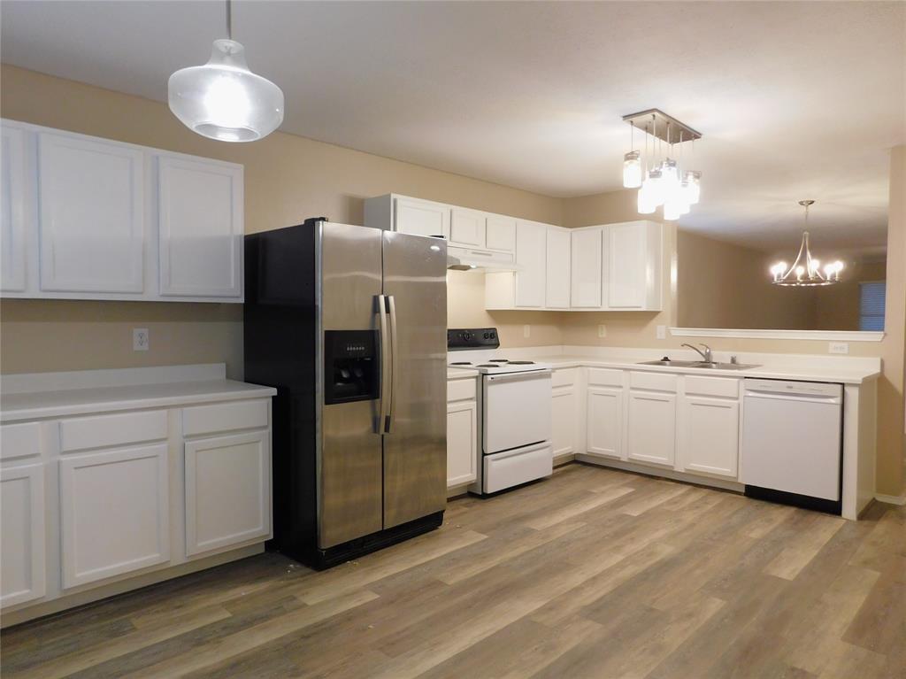 8105 Winding Stream Lane Denton, TX 76210 - Photo 10 of 28 a kitchen with white cabinets and white appliances
