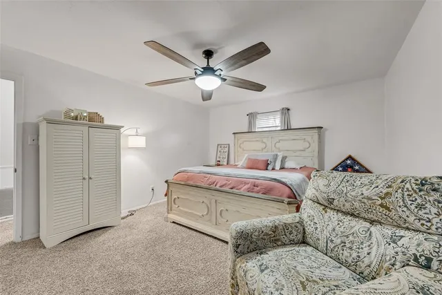 a bedroom with a bed and a ceiling fan
