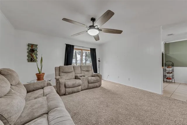 a living room with furniture and a ceiling fan