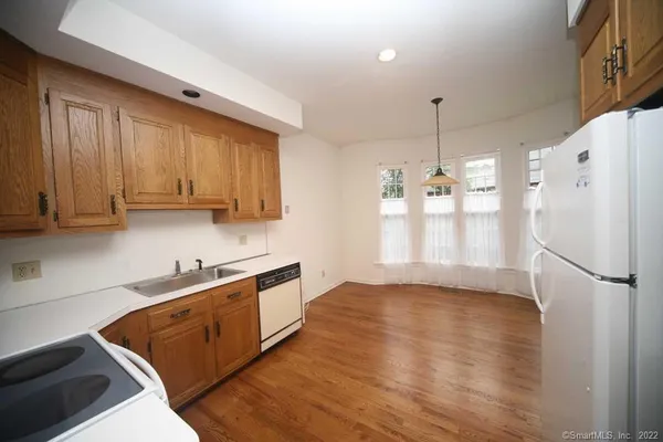 a kitchen with stainless steel appliances granite countertop a refrigerator a sink dishwasher a stove with wooden cabinets and floor