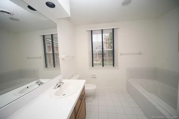a bathroom with a tub sink and mirror