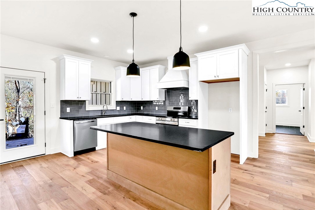 201 Whispering River Drive Crumpler, NC 28617 - Photo 15 of 48 a kitchen with stainless steel appliances granite countertop a sink a stove and a wooden floors