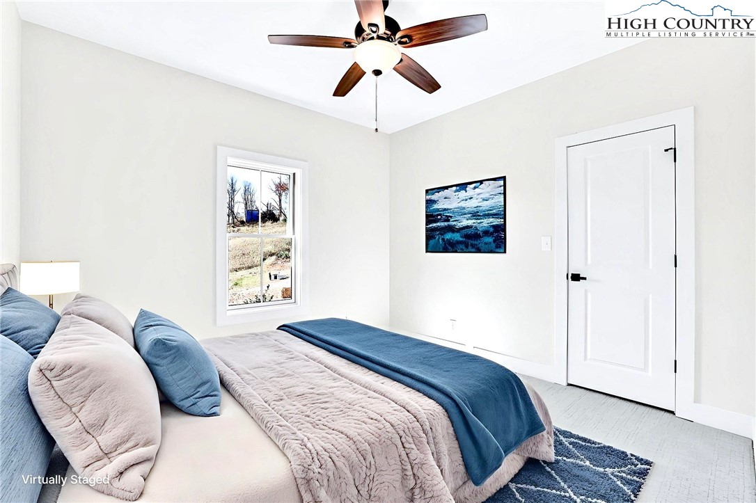 201 Whispering River Drive Crumpler, NC 28617 - Photo 35 of 48 a bedroom with a bed and a chandelier