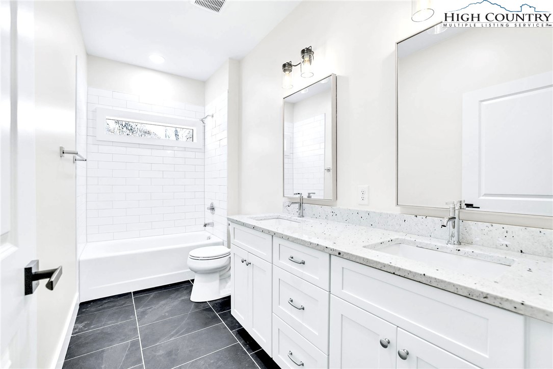 201 Whispering River Drive Crumpler, NC 28617 - Photo 37 of 48 a bathroom with a double vanity sink toilet mirror and bathtub