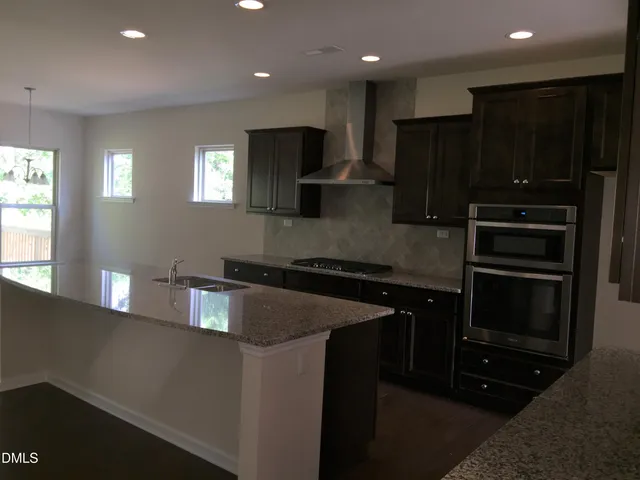 a kitchen with kitchen island granite countertop stainless steel appliances and cabinets