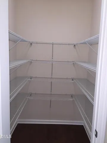 a view of walk in closet with empty racks