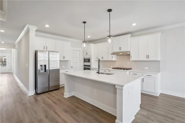 a kitchen with stainless steel appliances kitchen island granite countertop a stove and a sink