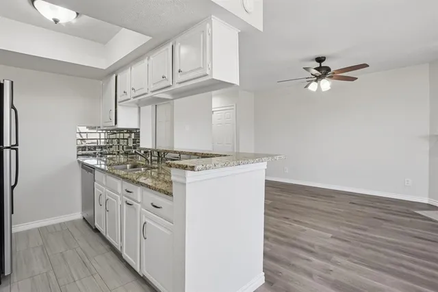 a kitchen with kitchen island a stove cabinets and wooden floor