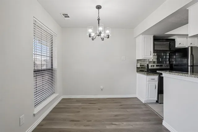 a view of a kitchen with a sink dishwasher oven and wooden floor