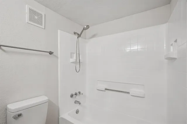 a bathroom with a shower a toilet and sink