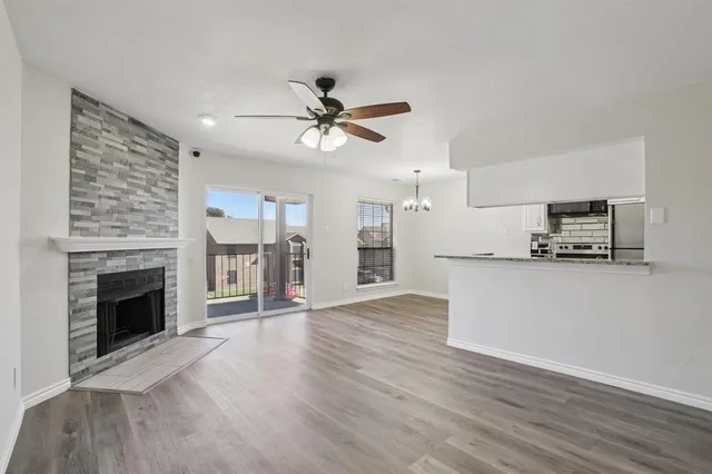 a view of empty room with wooden floor and fireplace
