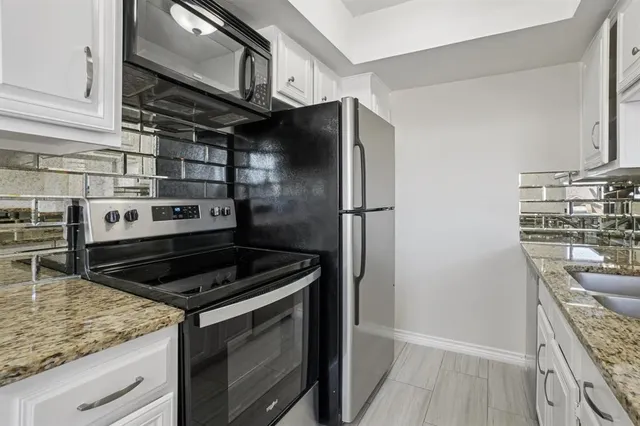 a kitchen with stainless steel appliances granite countertop a stove and a refrigerator