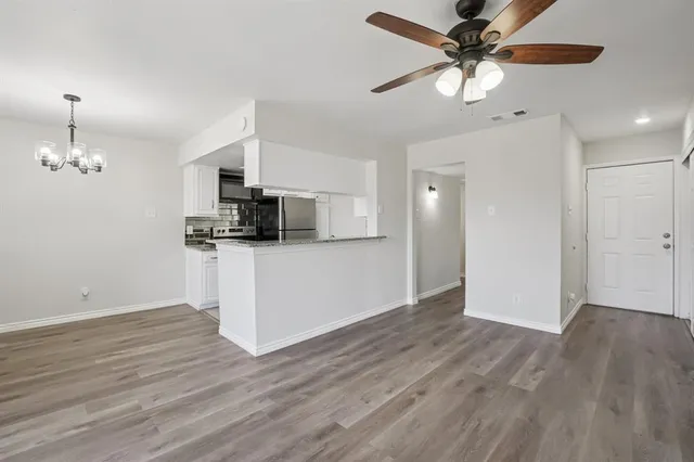 a view of a kitchen with a dishwasher a kitchen island hardwood floor and a ceiling fan
