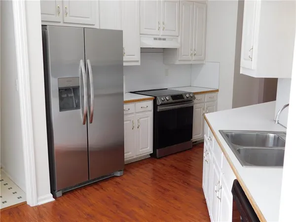 a kitchen with stainless steel appliances granite countertop a refrigerator sink and cabinets